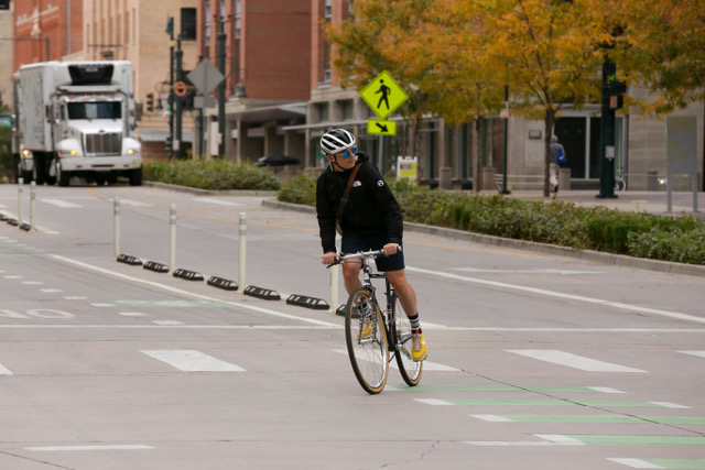 Cyclist riding in a protected bike lane on a Denver roadway