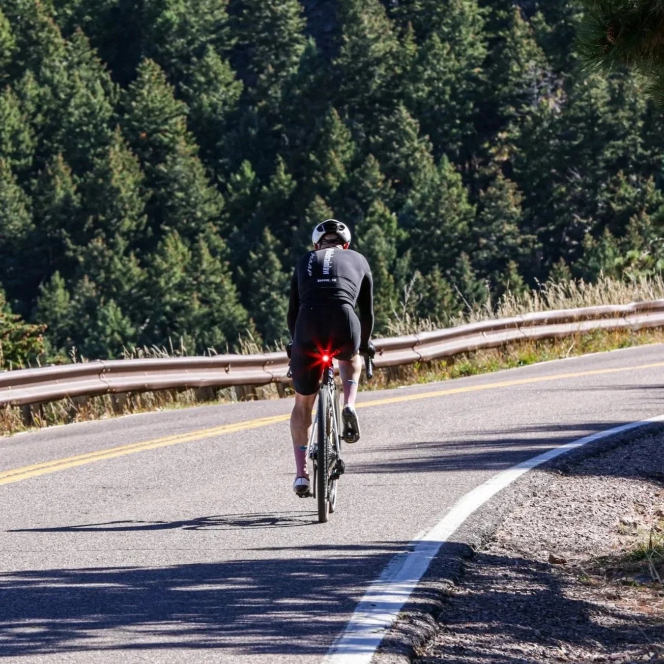 Cyclist riding uphill on a Colorado mountain road near Boulder